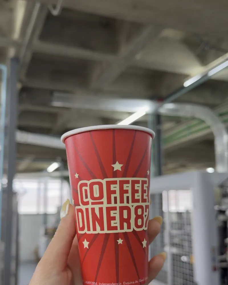Vaso rojo de Coffee Diner 87 en la planta